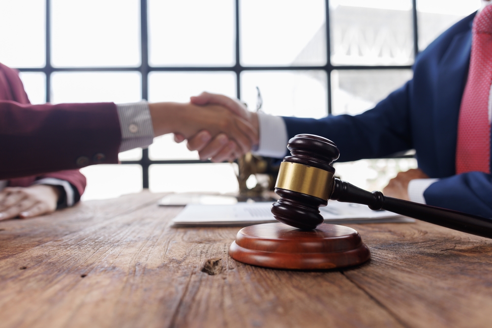 Male lawyer with client shaking hands in office,Justice and real estate